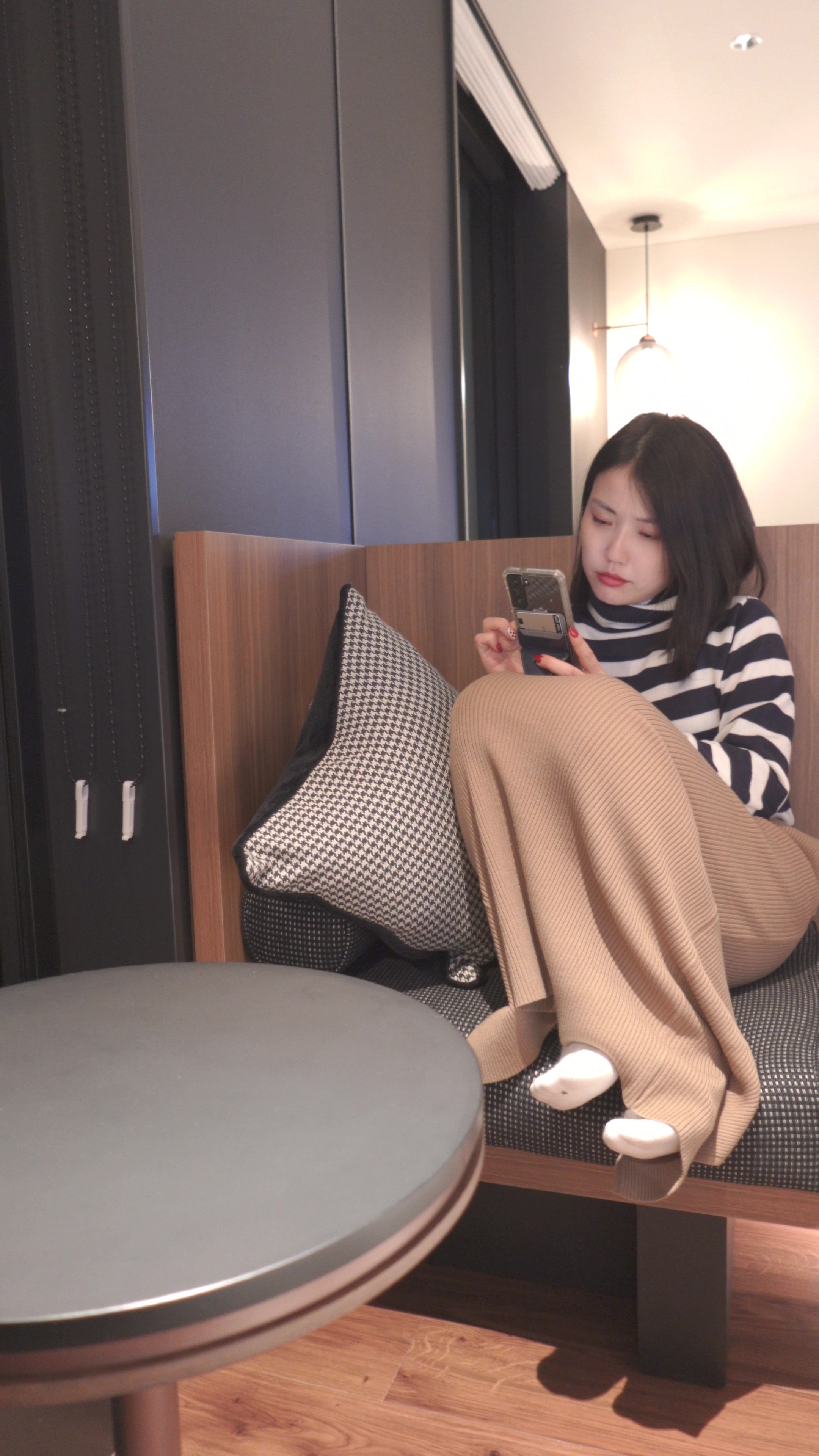 スマートフォンを見ながら考え込む女性のイメージ