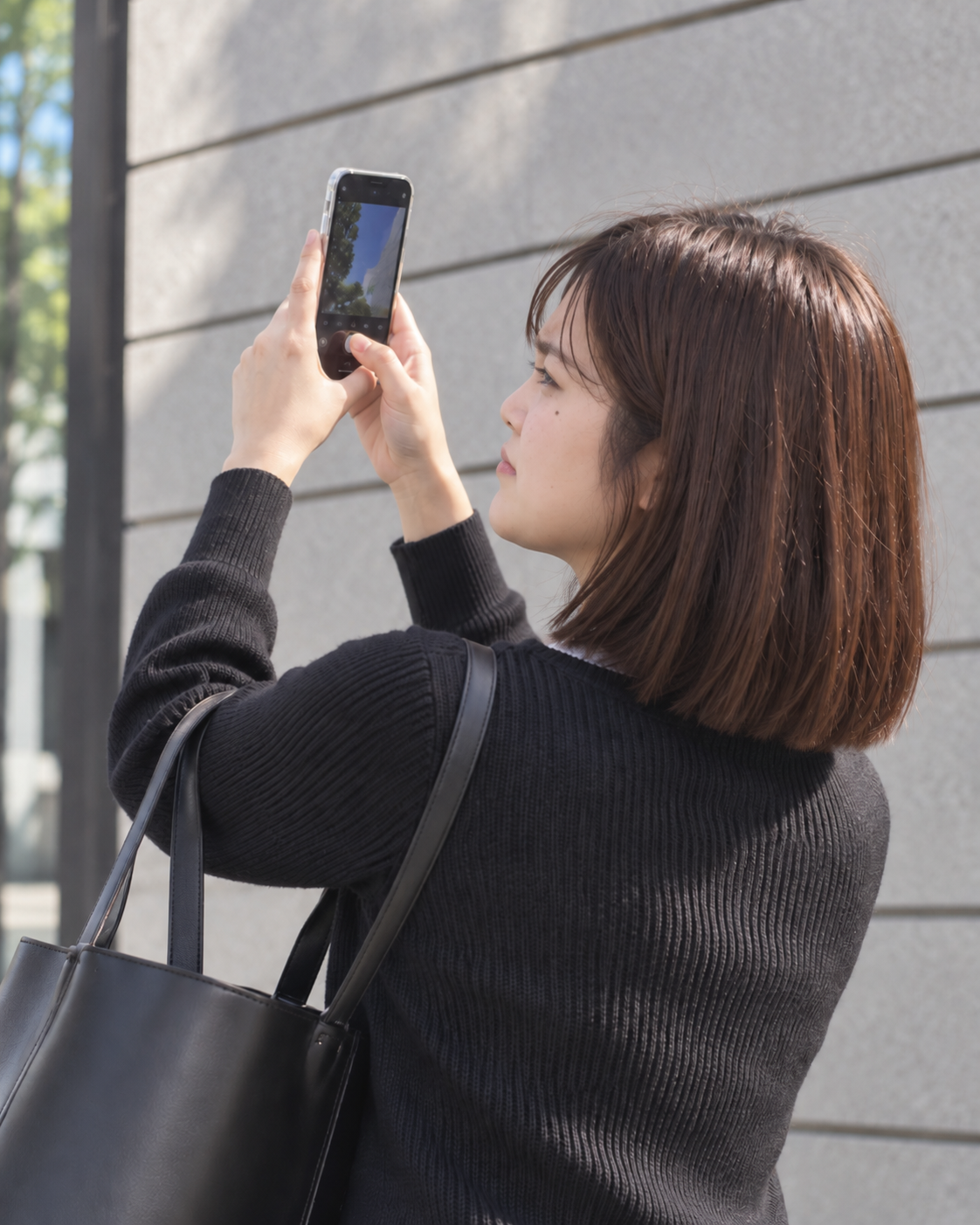 スマートフォンでお出かけ先を撮影する女性のイメージ